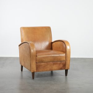 Luxe fauteuil gemaakt van rundleer met een mooie warme kleurstelling en een tijdloos Engels design