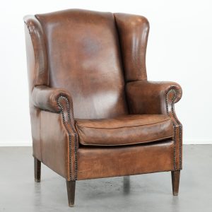 Karaktervolle grote vintage oorfauteuil gemaakt van schapenleer met mooie kleuren en een comfortabele zit