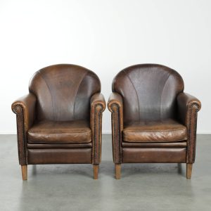 Tijdloze, luxe en karaktervolle set van twee schapenleren design armchairs/ fauteuils met een prachtig patina