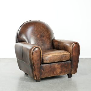Tijdloze, luxe en karaktervolle fauteuil van comfortabel schapenleer in Art Deco design met een prachtig patina