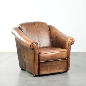 Mooi vormgegeven en comfortabele schapenleren fauteuil met een tijdloze uitstraling en een afwerking met meekleurende biezen