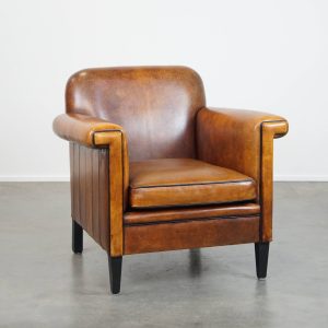 In goede staat verkerende schapenleren Art Deco design fauteuil met een strakke afwerking met zwarte biezen