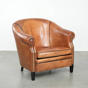 Grote schapenleren clubfauteuil in Engelse stijl met een mooie kleur, afgewerkt met siernagels en zwarte biezen in uniek formaat