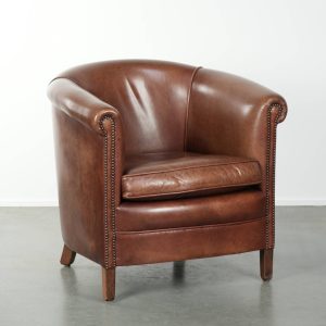 Rundleren clubfauteuil in een mooie donkere cognac kleur in Engelse stijl afgewerkt met siernagels
