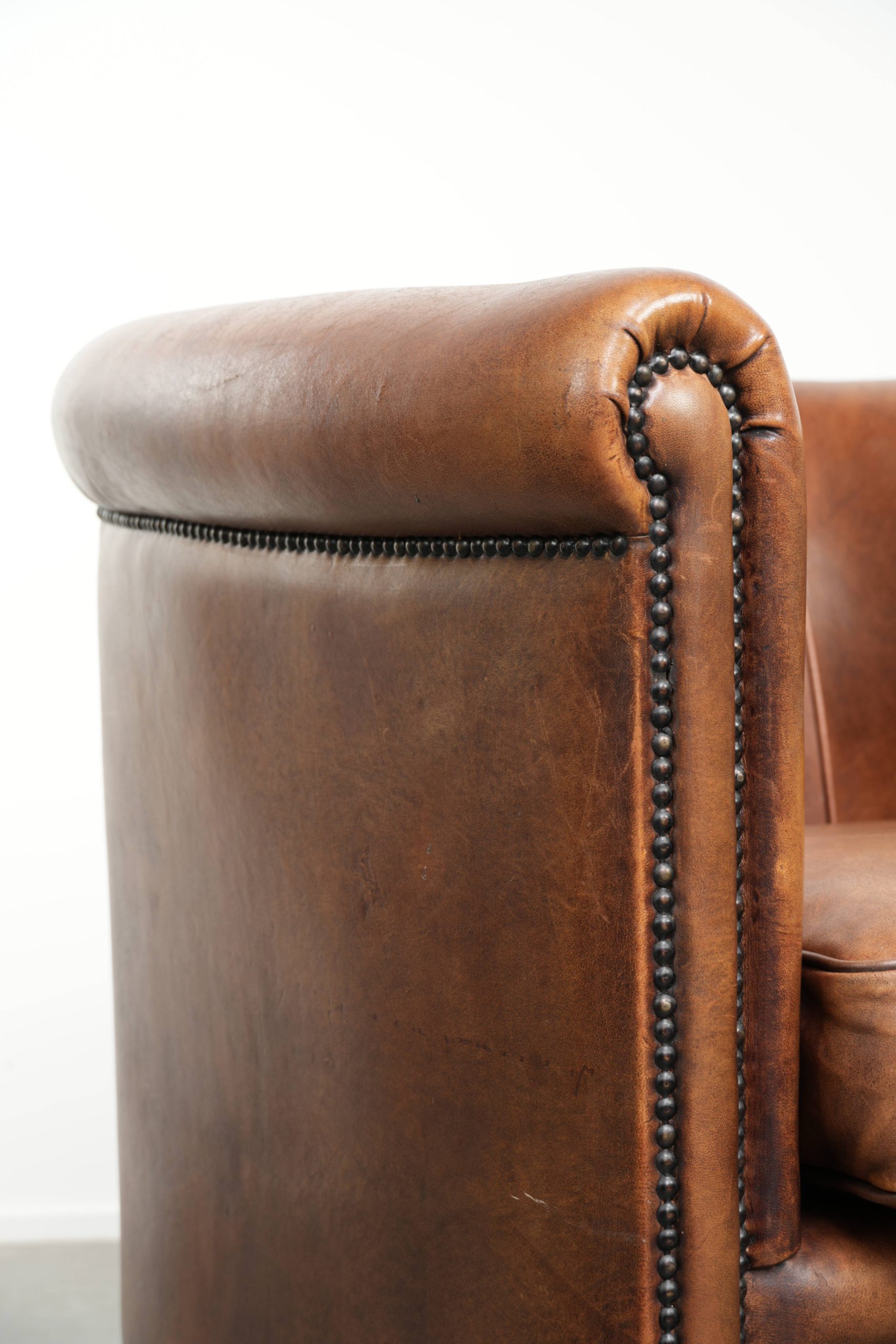 Karaktervolle schapenleren clubfauteuil met een warme cognac kleur afgewerkt met siernagels - Afbeelding 11