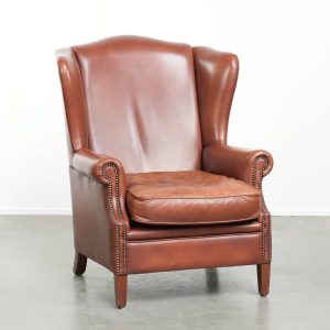 Comfortabele rundleren cognac kleurige oorfauteuil in Engelse stijl met een warme uitstraling