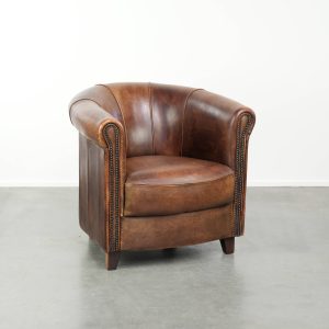 Stoere en karaktervolle schapenleren clubfauteuil met een mooi patina afgewerkt met siernagels 