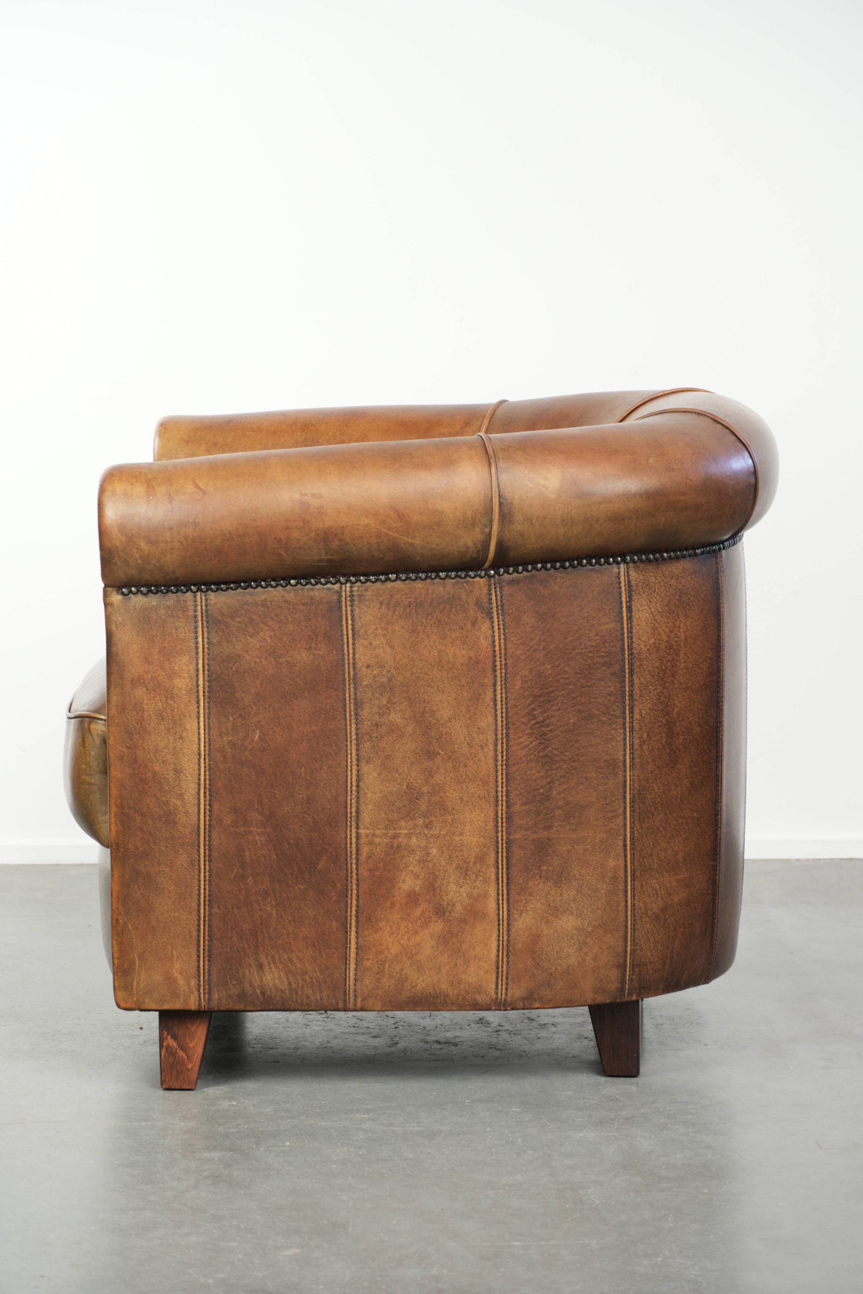 Stoere en karaktervolle schapenleren clubfauteuil met een mooi patina afgewerkt met siernagels - Afbeelding 5