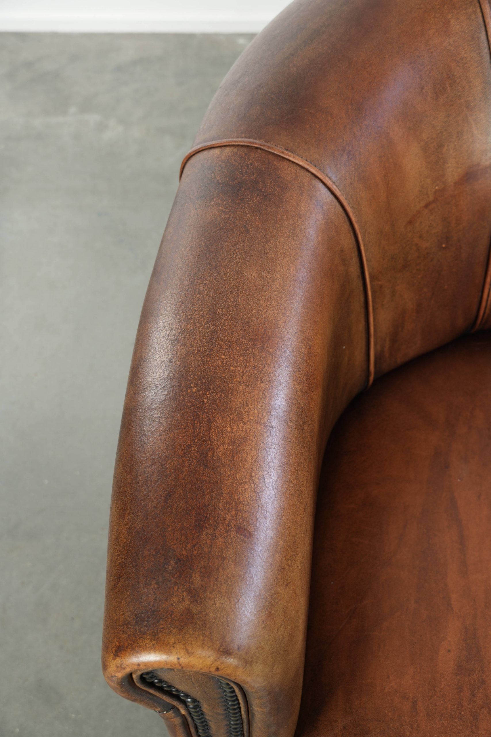 Stoere en karaktervolle schapenleren clubfauteuil met een mooi patina afgewerkt met siernagels - Afbeelding 7
