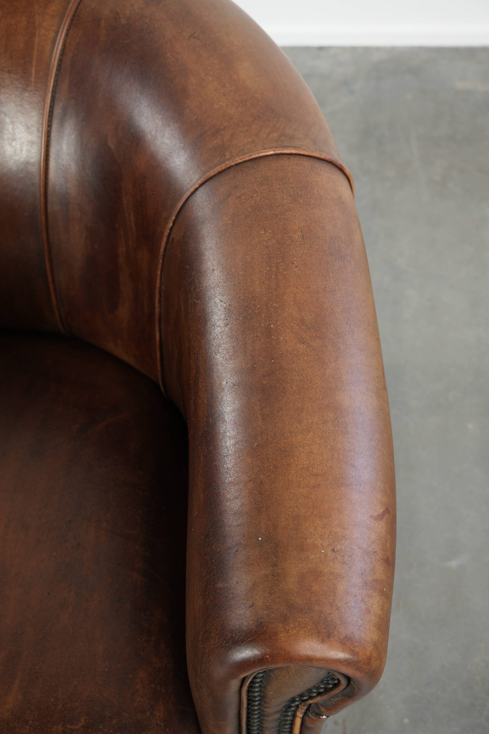 Stoere en karaktervolle schapenleren clubfauteuil met een mooi patina afgewerkt met siernagels - Afbeelding 8