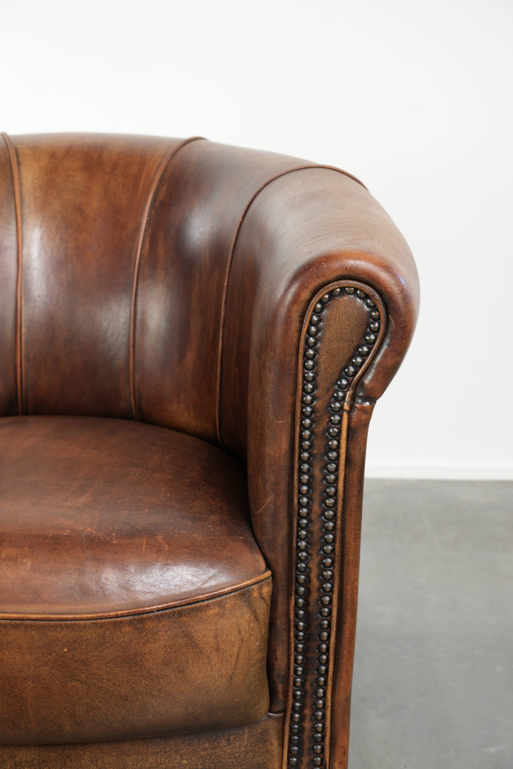 Stoere en karaktervolle schapenleren clubfauteuil met een mooi patina afgewerkt met siernagels - Afbeelding 9
