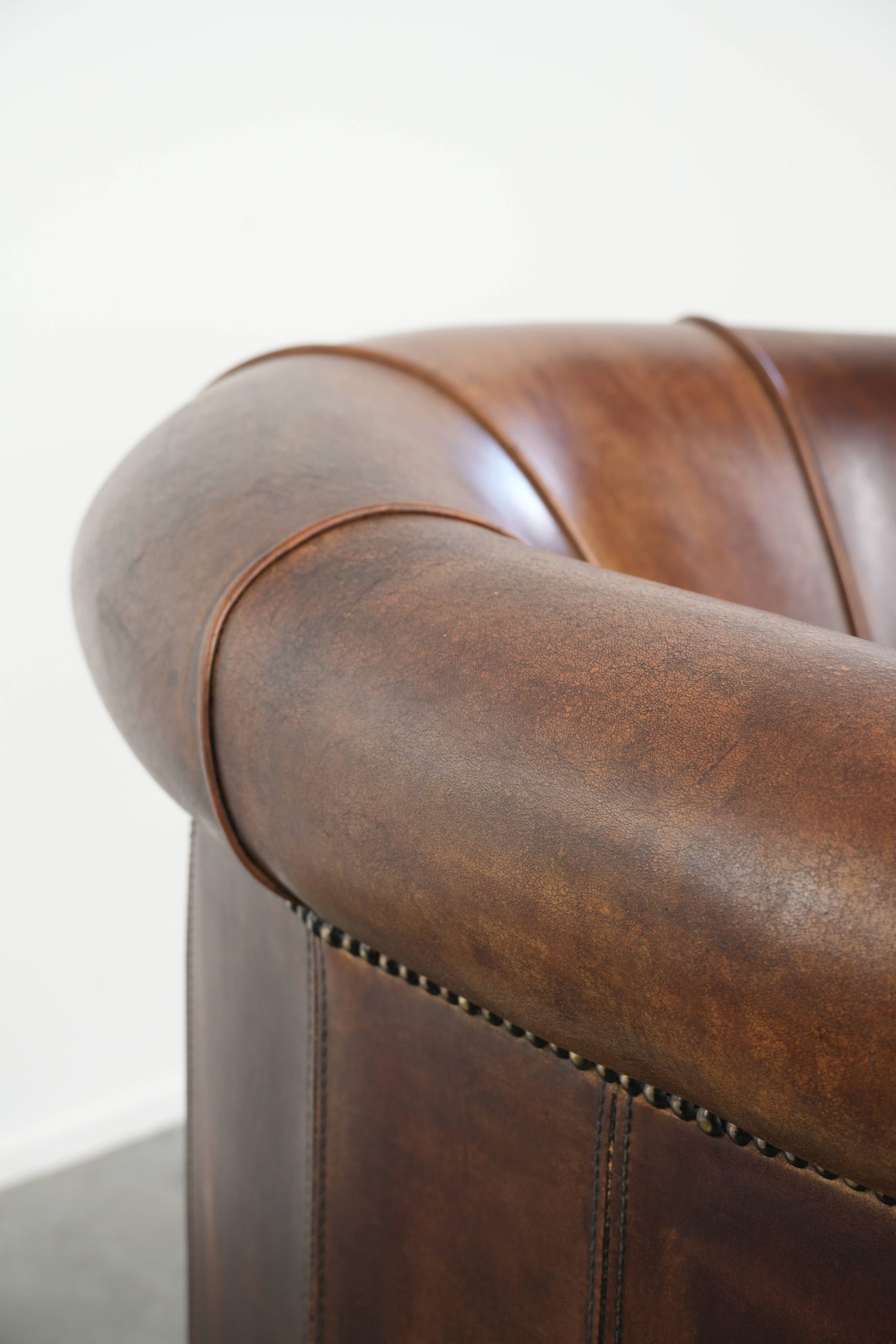 Stoere en karaktervolle schapenleren clubfauteuil met een mooi patina afgewerkt met siernagels - Afbeelding 10