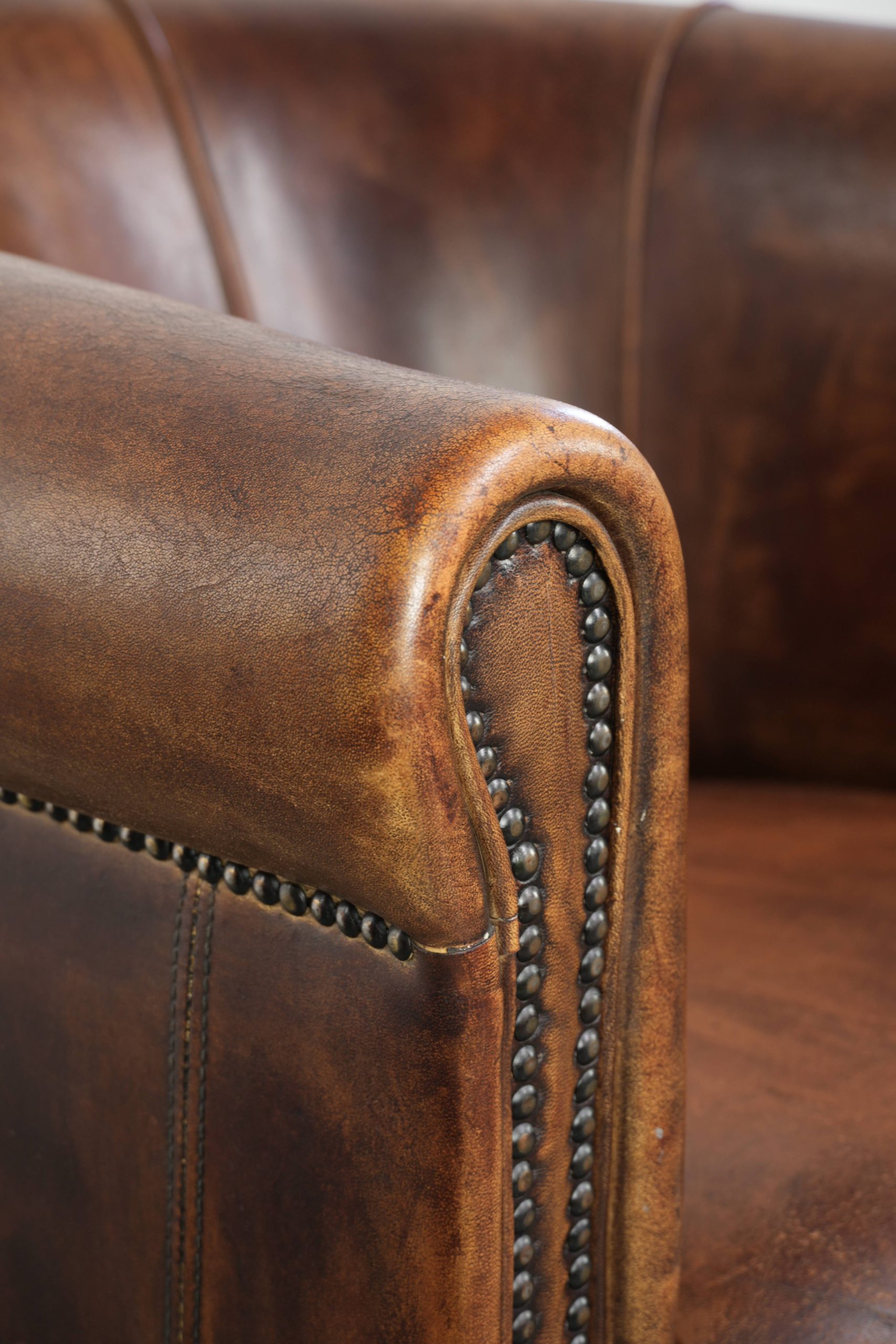Stoere en karaktervolle schapenleren clubfauteuil met een mooi patina afgewerkt met siernagels - Afbeelding 11