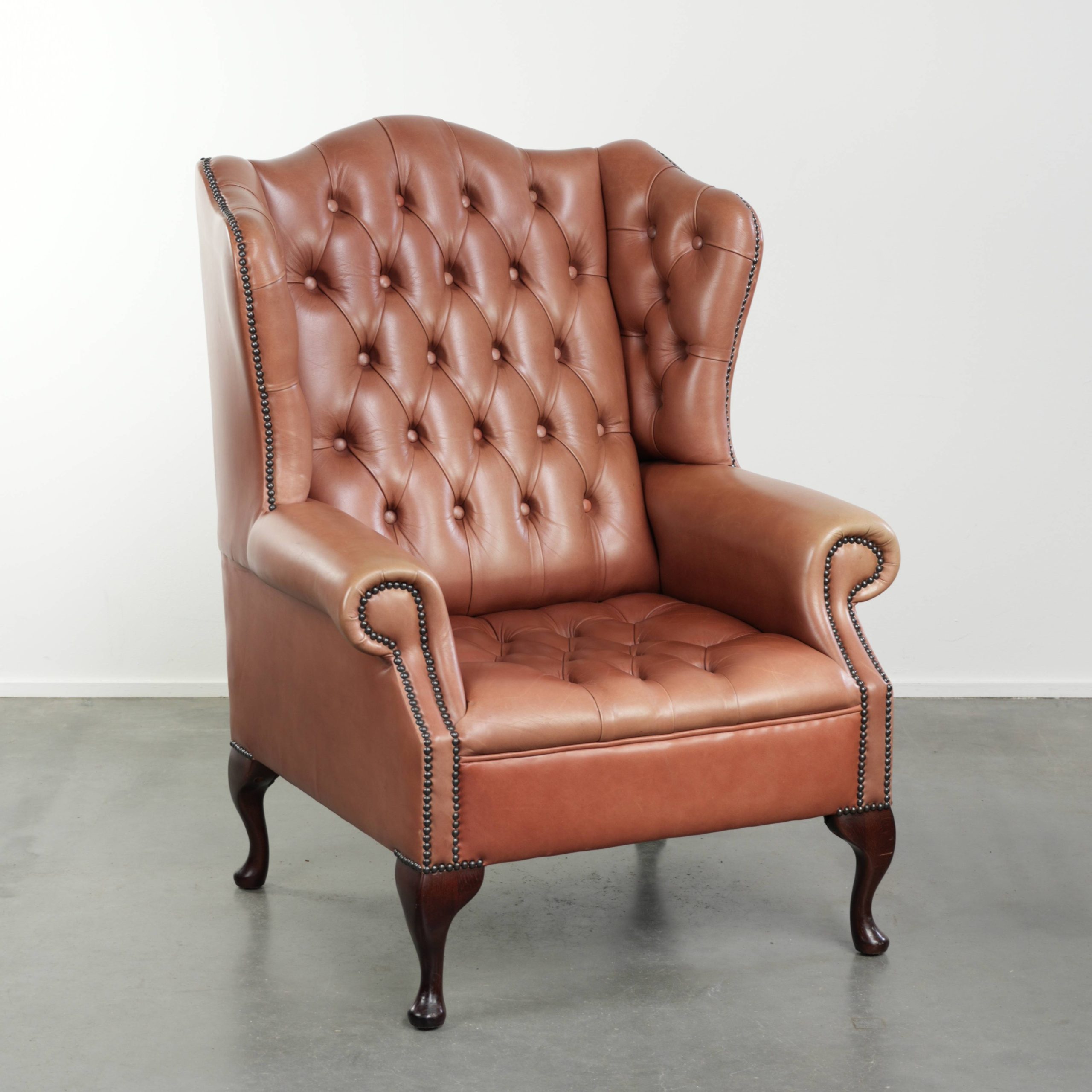 Klassieke Engelse rundleren button seat chesterfield oorfauteuil met een prachtig patina en mooie kleuren