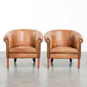 Subtiele set van twee karaktervolle vintage schapenleren clubfauteuils met een mooie lichte kleur en een mooie patina look