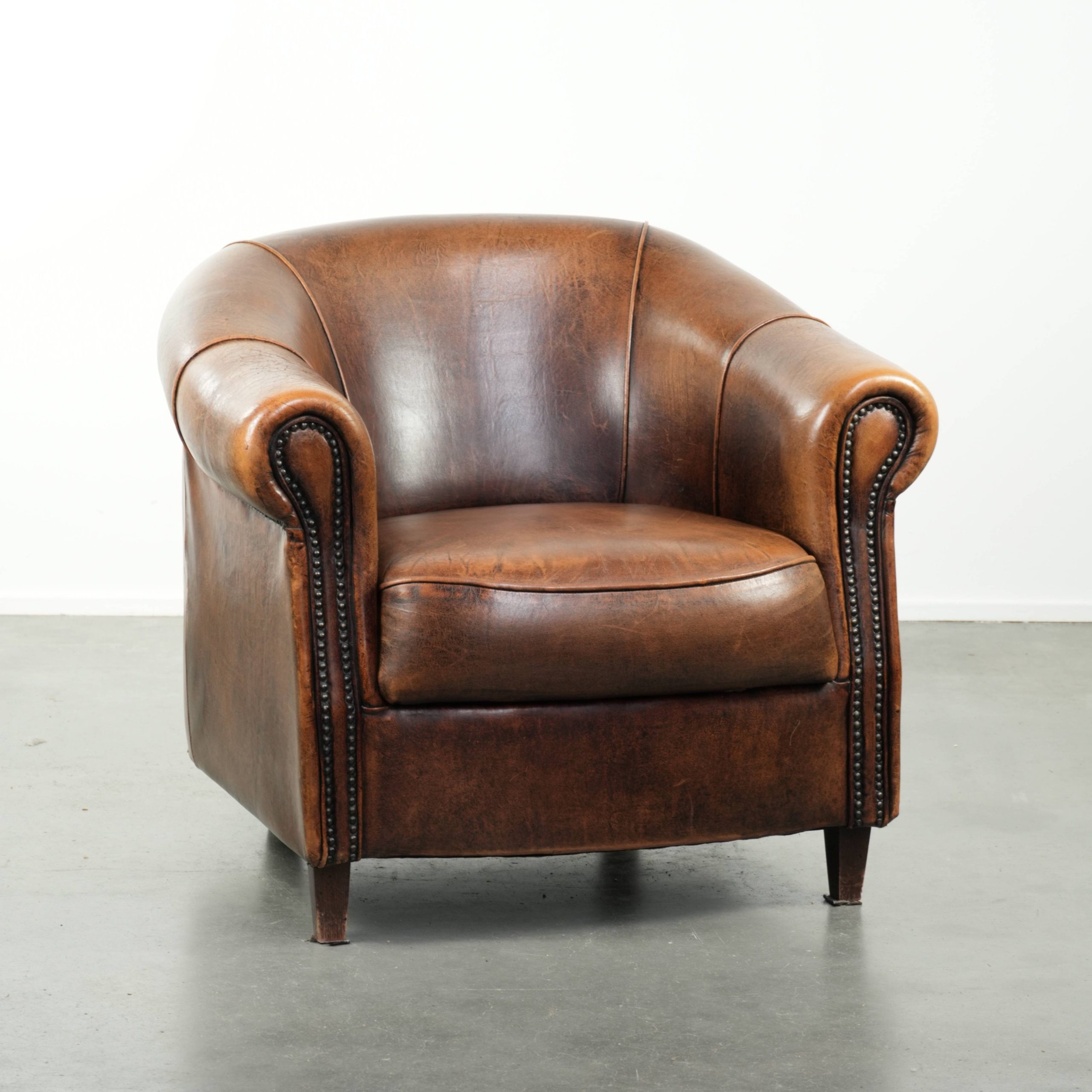 Karaktervolle en comfortabele clubfauteuil gemaakt van schapenleer met een vast zitkussen en uitmuntende kleuren