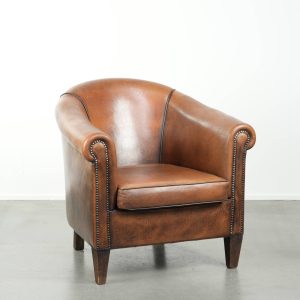 Karaktervolle en comfortabele schapenleren clubfauteuil met een mooie patina en een verfijnde afwerking met zwarte biezen
