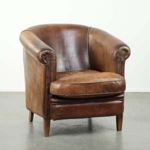 Stoere en begeerlijke vintage schapenleren clubfauteuil met een mooi patina en warme kleuren