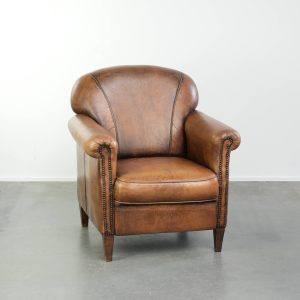 Comfortabele karaktervolle schapenleren armchair afgewerkt met siernagels en een mooi patina