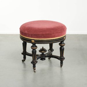 Antiek Engelse stool/krukje met een rode stoffen zit en een zwart houten onderstel afgewerkt met goudkleurige details