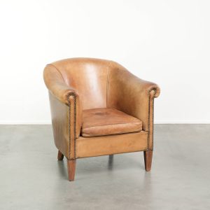 Karaktervolle schapenleren clubfauteuil in een lichte cognac kleur afgewerkt met siernagels