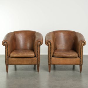 Stoere set van 2 grote vintage schapenleren clubfauteuils met een prachtig patina