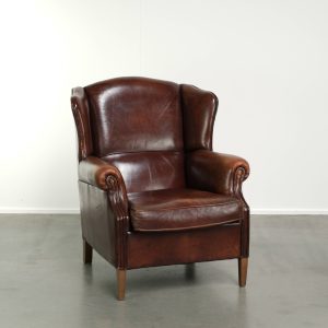 Statige schapenleren oorfauteuil met een mooie warme kastanjekleur en een comfortabele zit