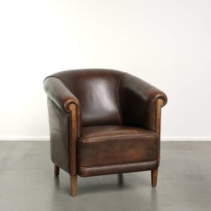 Vintage en stoere schapenleren clubfauteuil uitgevoerd met biezen en een vast zitkussen