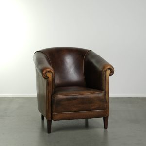 Aantrekkelijke donkere schapenleren clubfauteuil met een fijn zitcomfort