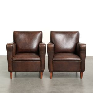 Stoere set vintage schapenleren armchairs in een mooie donkere kleur met een leuk Engels design