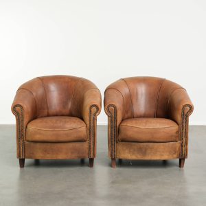 Stoere set vintage schapenleren clubfauteuils met een mooi geleefd uiterlijk en een geweldige uitstraling