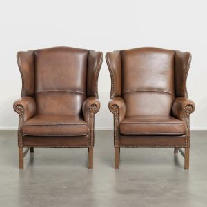 Charmante set van 2 rundleren oorfauteuils in Engelse stijl afgewerkt met siernagels