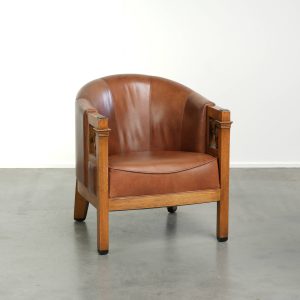 Rundleren Art Deco design clubfauteuil uit begin 20e eeuw in een zachte cognac kleur met prachting houtsnijwerk