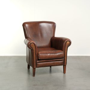 Schapenleren armchair in een donkere cognac kleur met een elegante uitstraling