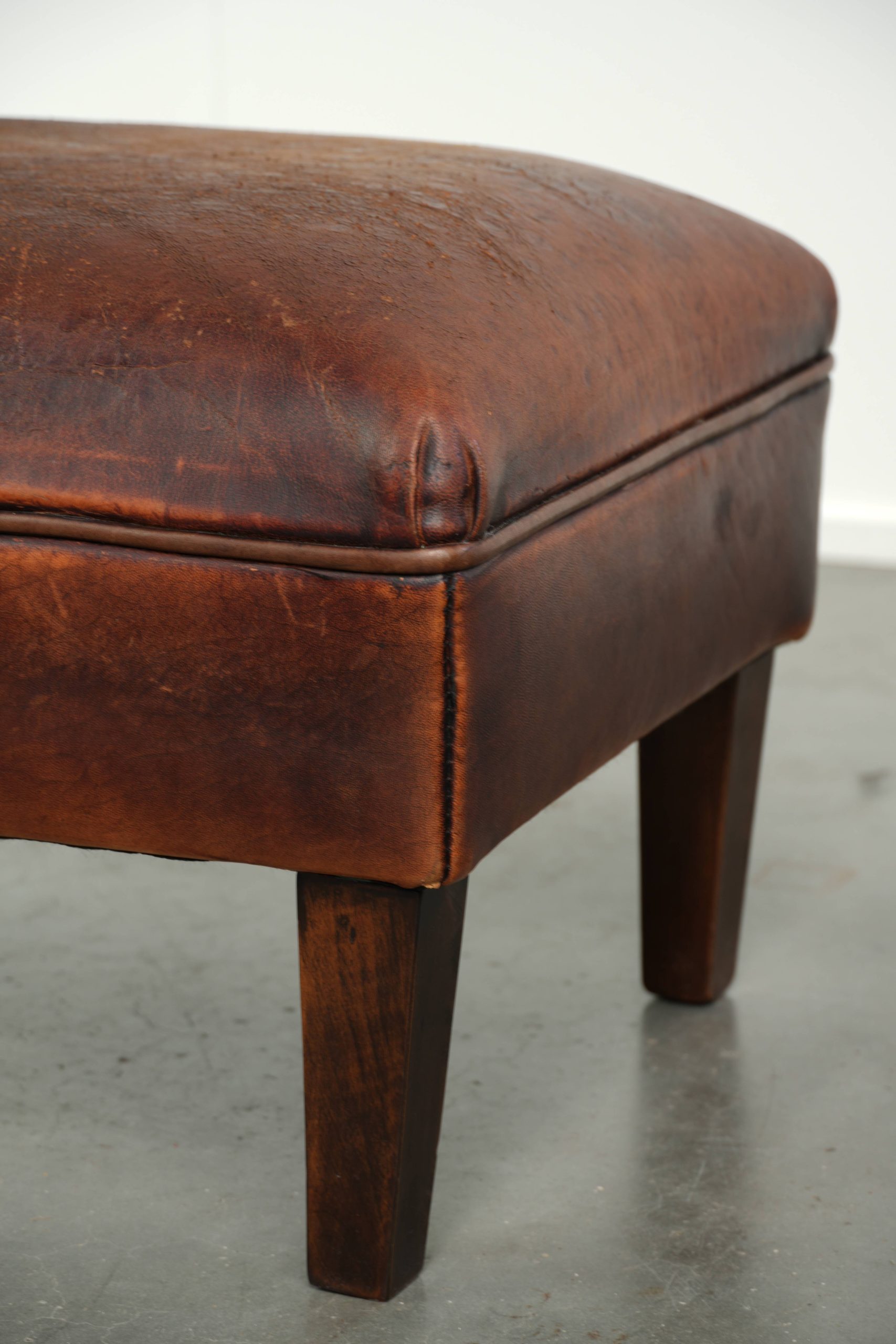 Vintage schapenleren hocker in een bruine kleurstelling met een tijdloze uitstraling - Afbeelding 9