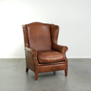 Rundleren oorfauteuil in Engelse stijl met een mooie cognac kleur afgewerkt met siernagels