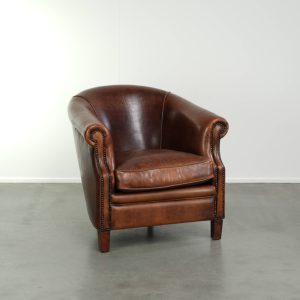 Vintage schapenleren clubfauteuil in een warme bruine kleur afgewerkt met siernagels