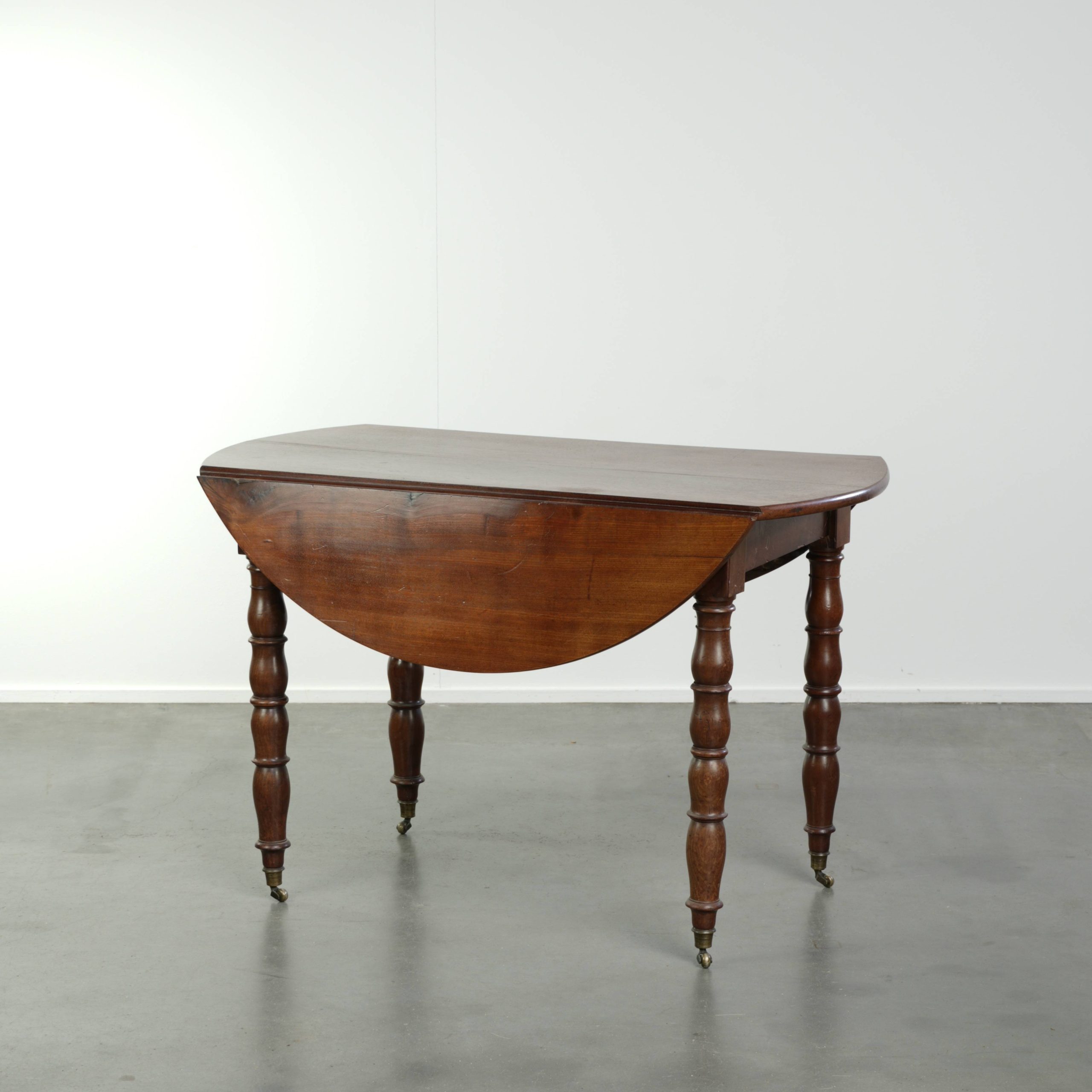 Antieke hangoor tafel uit eind 19e eeuw in subtiel formaat met mooi houtsnijwerk en wieltjes