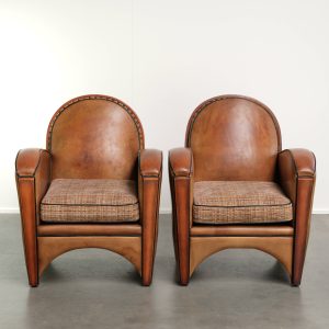 Set van 2 unieke schapenleren armchairs in Art deco stijl met een stoffen zitting in een leuk patroon afgewerkt met zwarte biezen
