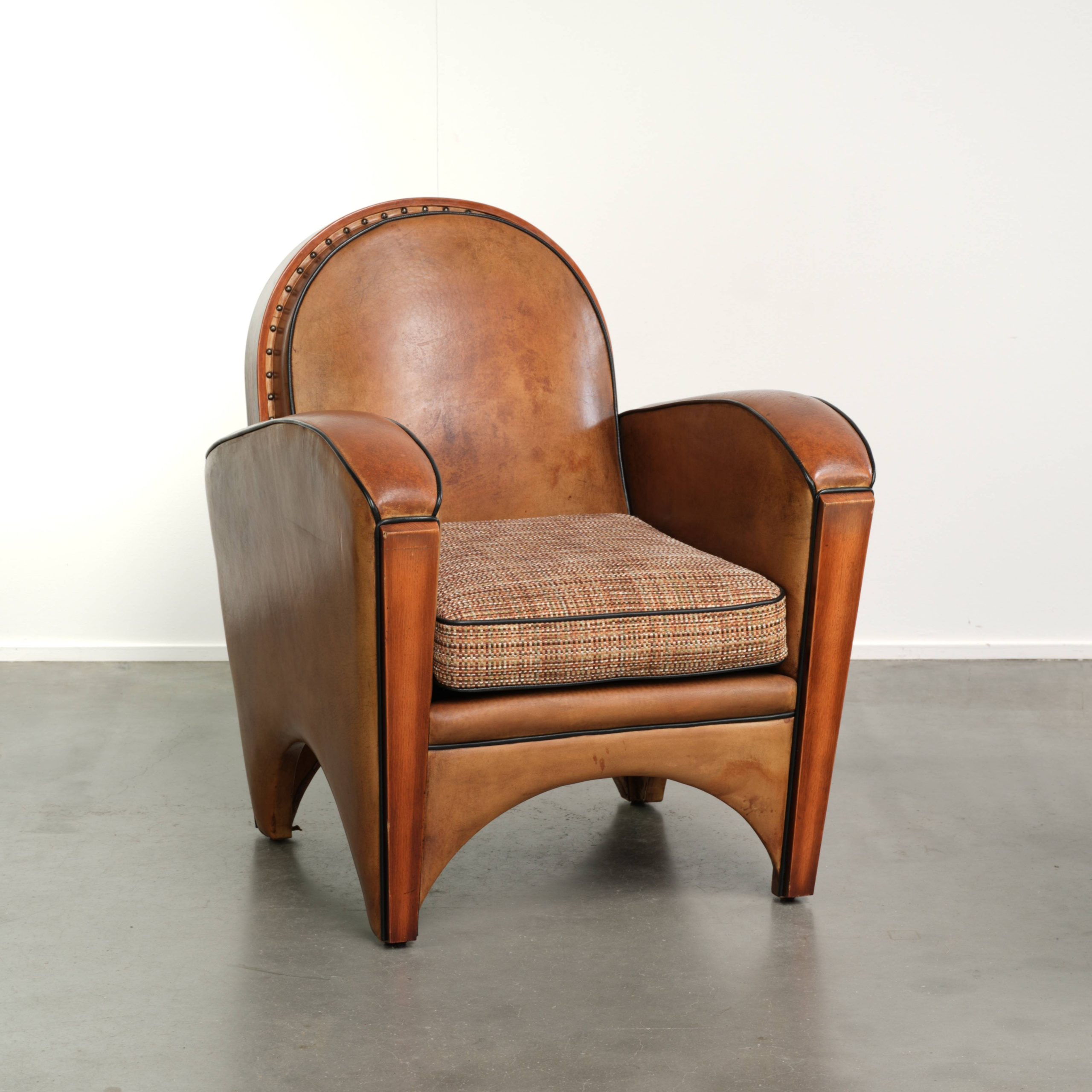 Schapenleren Art Deco armchair in een warme cognac kleur met een stoffen zitting in een leuk patroon