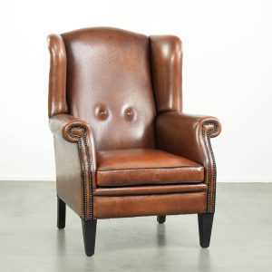 Luxe schapenleren oorfauteuil afgewerkt met zwarte biezen en een correcte zit