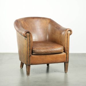 Vintage schapenleren clubfauteuil afgewerkt met siernagels en een elegante uitstraling
