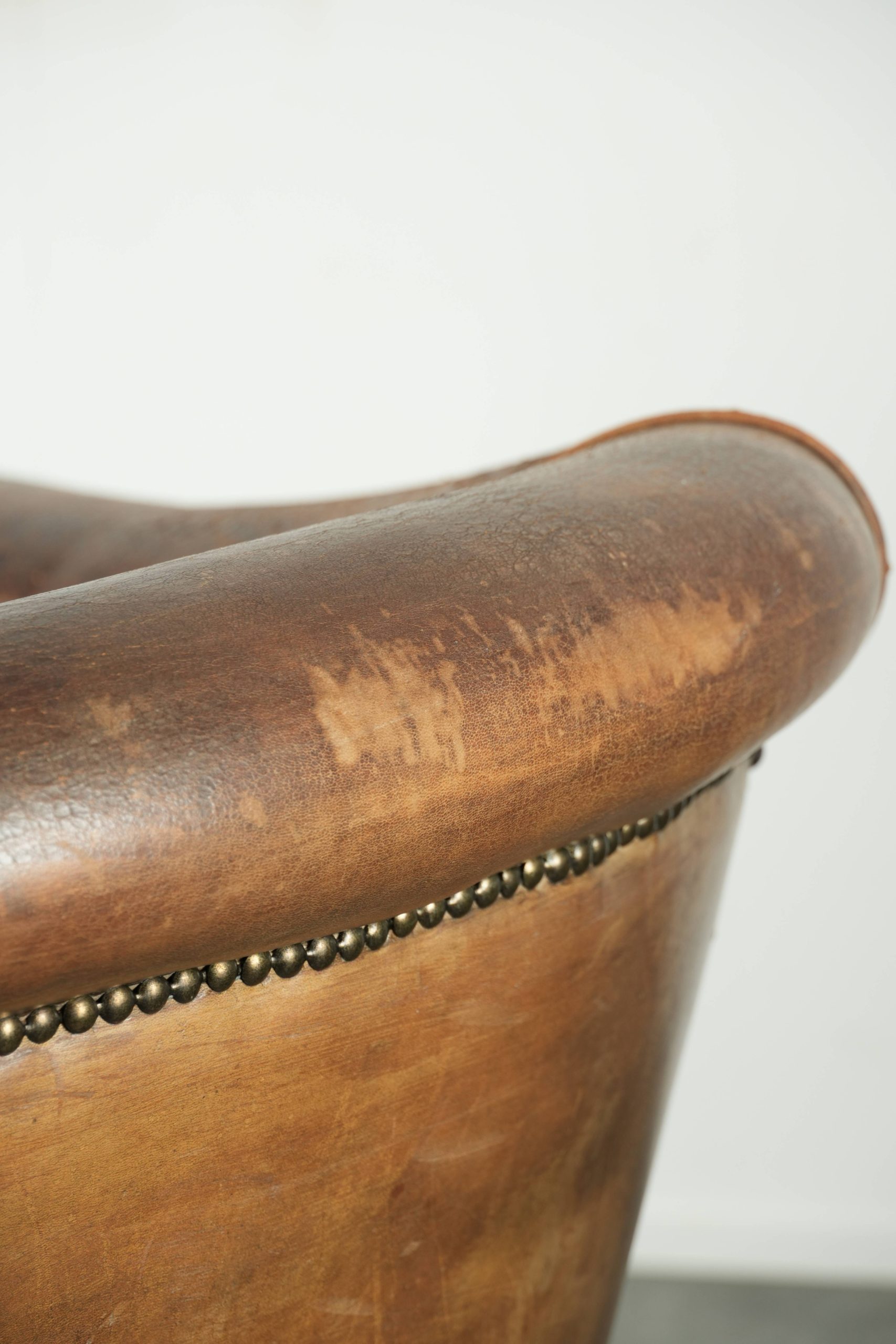 Vintage schapenleren clubfauteuil afgewerkt met siernagels en een elegante uitstraling - Afbeelding 17
