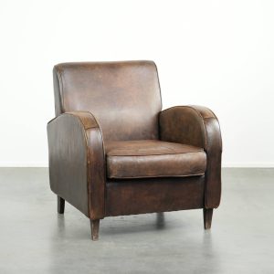 Comfortabele schapenleren armchair met meekleurende biezen en een tijdloze uitstraling