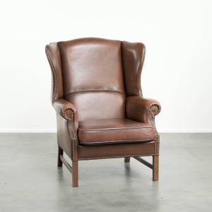 Elegante rundleren oorfauteuil in Engelse stijl afgewerkt met siernagels een een comfortabele zit