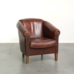 Schapenleren clubfauteuil in Engelse stijl met een bruine kleurstelling afgewerkt met siernagels