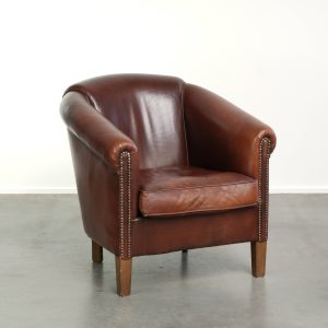 Karaktervolle schapenleren clubfauteuil in een donkere cognac kleur in Engelse stijl